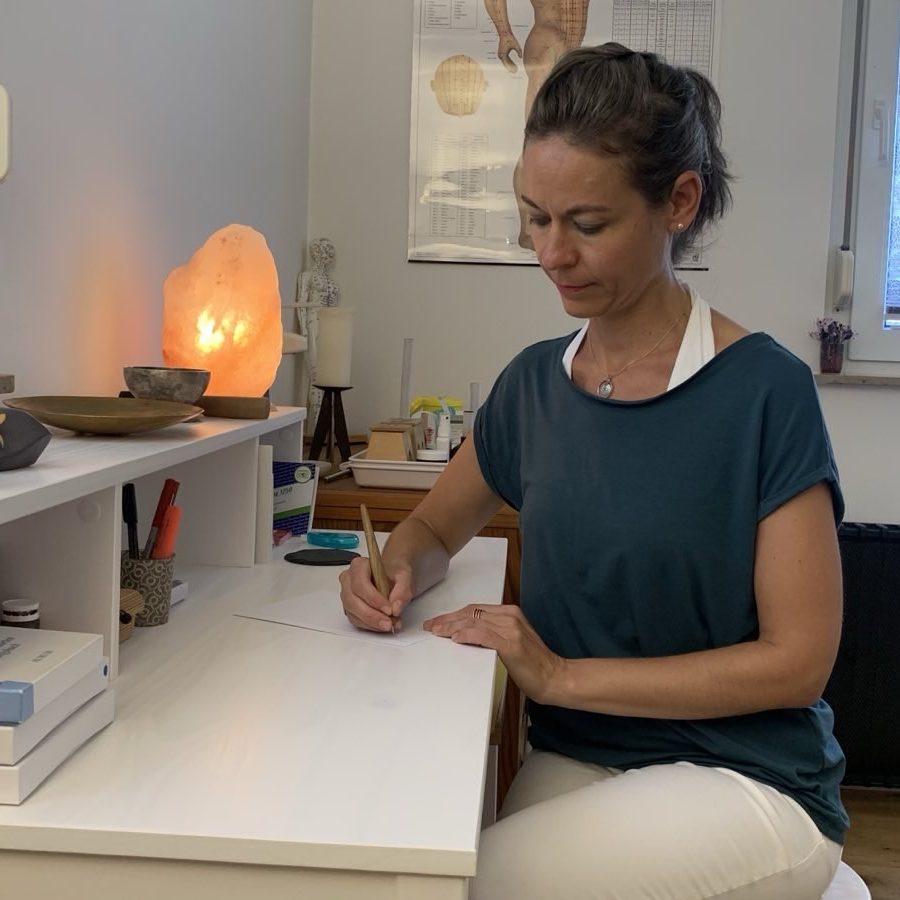 Heilpraktikerin sitzt in ihrer Praxis auf einem bequemen Sessel