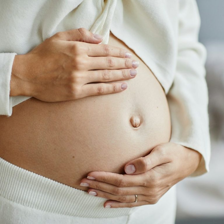Schwangere Frau hält ihren Babybauch