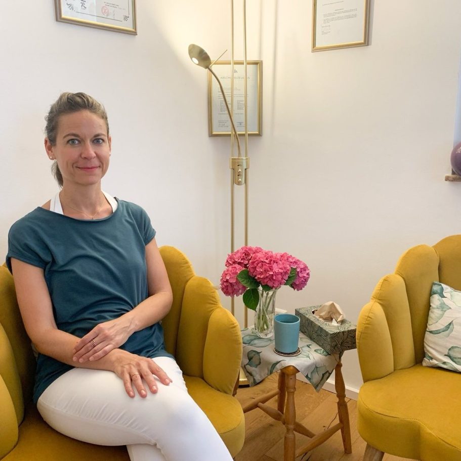 Heilpraktikerin sitzt in ihrer Praxis auf einem bequemen Sessel
